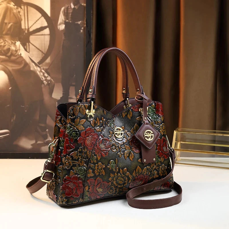 Sac à main rétro sculpté Floral en cuir synthétique noir à motif fleurs rouges et dorées, poignées et bandoulière marron.