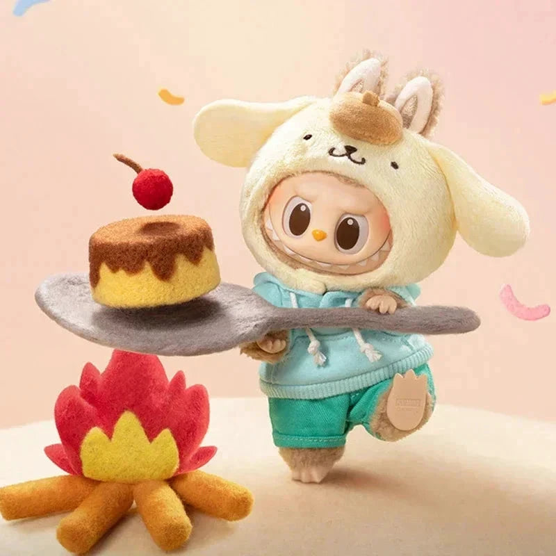 Porte-clé peluche POP MART Labubu Hello Kitty; personnage beige avec capuche à oreilles et hoodie turquoise, gâteau sur plateau gris.